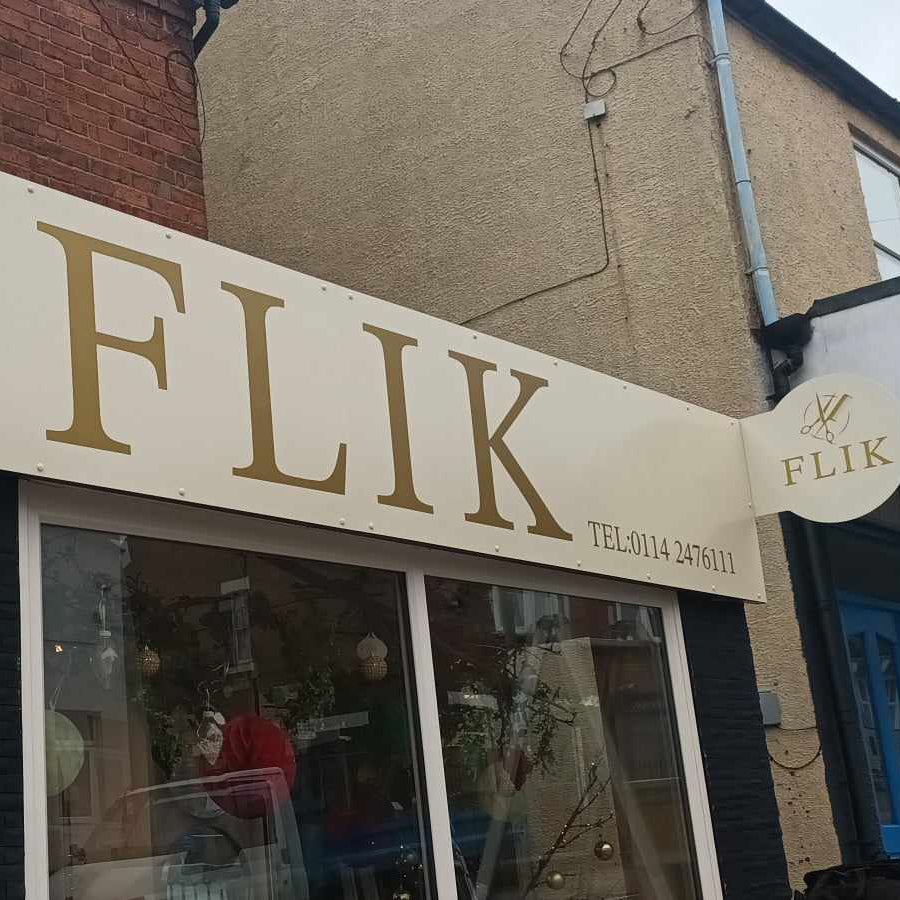 Storefront with 'FLIK' signage on a building corner.